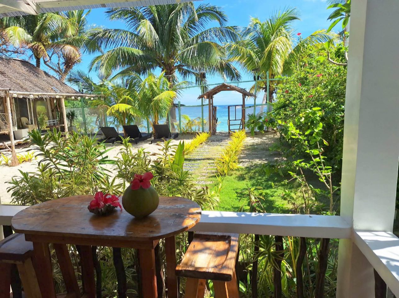 Balcony view from Happy's Homestay — lush tropical garden and ocean